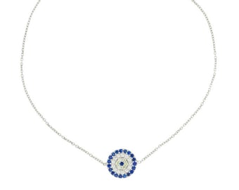 Puede incluir: Un brazalete de cadena de plata con un dije de ojo turco azul y blanco. El dije está rodeado de pequeñas piedras blancas y azules.