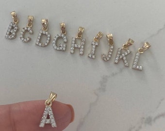 May include: A set of gold letter pendants with clear crystal accents. The letters are A, B, C, D, G, H, I, J, K, and L.