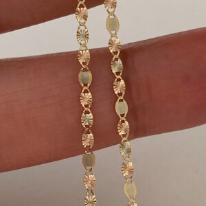 May include: Two gold chains with a diamond-shaped pattern on each link. The chains are made of 10k gold and are 20 inches long.