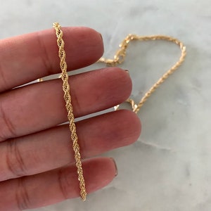 May include: A gold rope chain necklace. The chain is made of a twisted rope design.