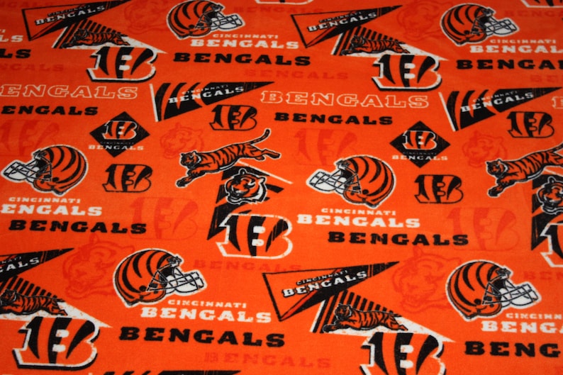 May include: Orange fabric with a repeating pattern of black and white Cincinnati Bengals logos, including the team's mascot, the number 13, and the words "Cincinnati Bengals".