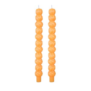May include: Two orange taper candles with a unique, textured design. Each candle is composed of stacked, spherical shapes, creating a decorative and eye-catching appearance. The candles have a classic taper shape, perfect for home decor.