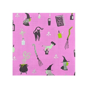 Puede incluir: Servilletas de papel rosas con un patrón repetido de brujas, gatos negros, calderos, escobas y frascos de pociones. El texto "Book of Spells" está impreso en un libro cerrado.