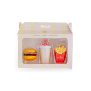 Peut inclure: Un coffret de baume à lèvres dans une boîte avec une fenêtre transparente, comprenant un hamburger, un milk-shake et des frites. La boîte est rayée de rose et de blanc. Les frites sont dans un contenant rouge avec le texte "I ❤️ SNACKS".