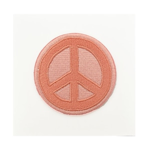 May include: A pink embroidered peace sign patch. The patch is round and has a white outline.