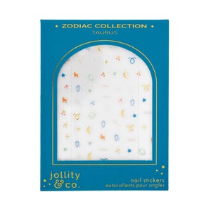 May include: A blue box with a clear window displaying nail stickers. The stickers feature colorful zodiac-themed designs, including stars, moons, and zodiac symbols. The box reads "Zodiac Collection Taurus" and "Jollity & Co."