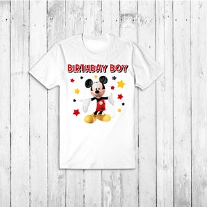 May include: White t-shirt featuring a red and black Mickey Mouse graphic and the text "Birthday Boy" in black. The graphic includes yellow and red stars.