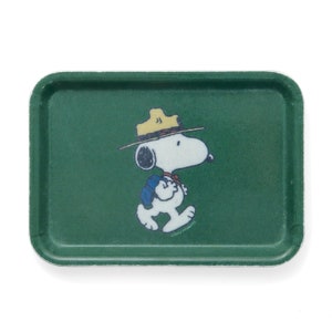 Könnte beinhalten: Ein grünes Tablett mit weißem Rand zeigt ein Cartoon-Bild von Snoopy, der als Park Ranger verkleidet ist. Snoopy trägt einen braunen Rangerhut, ein blaues Hemd und einen braunen Rucksack. Der Text "©1960 PEANUTS" ist unter Snoopy gedruckt.