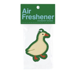 May include: An air freshener in a clear plastic package. The air freshener is shaped like a goose with a cream-colored body, green outline, and red accents. The packaging includes the words "Air Freshener" and "Cranberry-Orange" in white text on a green background.