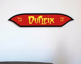 Könnte beinhalten: Ein rotes und schwarzes Schild mit dem Text "DUFLEIX" in gelben Buchstaben. Das Schild hat einen schwarzen Rand und den Text "Licence N° 6" an beiden Enden.