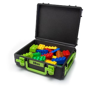 May include: A black and green plastic storage case with the word "SBOX" printed on the front. The case is open and filled with colorful plastic building blocks.