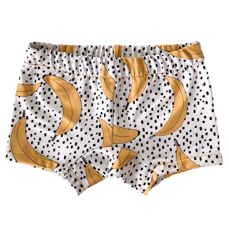 Pode incluir: Shorts de algod&atilde;o branco com estampa de bananas amarelas e bolinhas pretas.
