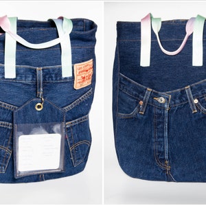 May include: A blue denim tote bag with a clear plastic pocket and a Levi's label. The bag has two rainbow-coloured straps.