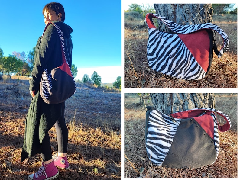 Puede incluir: Bolso de hombro con estampado de cebra, dise&ntilde;o de bloques de color rojo y negro. El bolso tiene una correa larga y una forma redondeada. El bolso se lleva al hombro. El fondo es un entorno natural al aire libre.