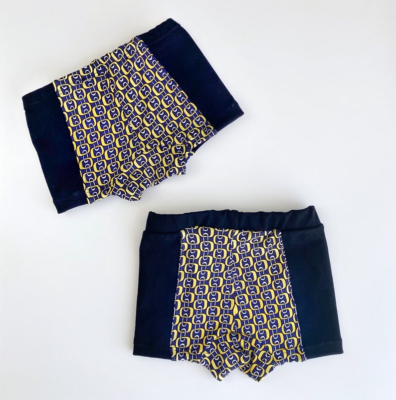 Pode incluir: Dois pares de roupa interior com padr&atilde;o preto e amarelo. A roupa interior tem uma cintura preta e um painel lateral preto.