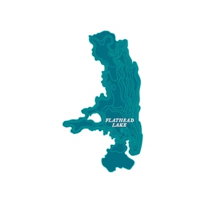 May include: A teal-colored topographic map of Flathead Lake, Montana, against a white background. The map features contour lines and the lake's name in white text. The design is a stylized representation of the lake's shape and depth.
