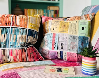 Double-sided multicolour cushion of vintage books and bus tickets