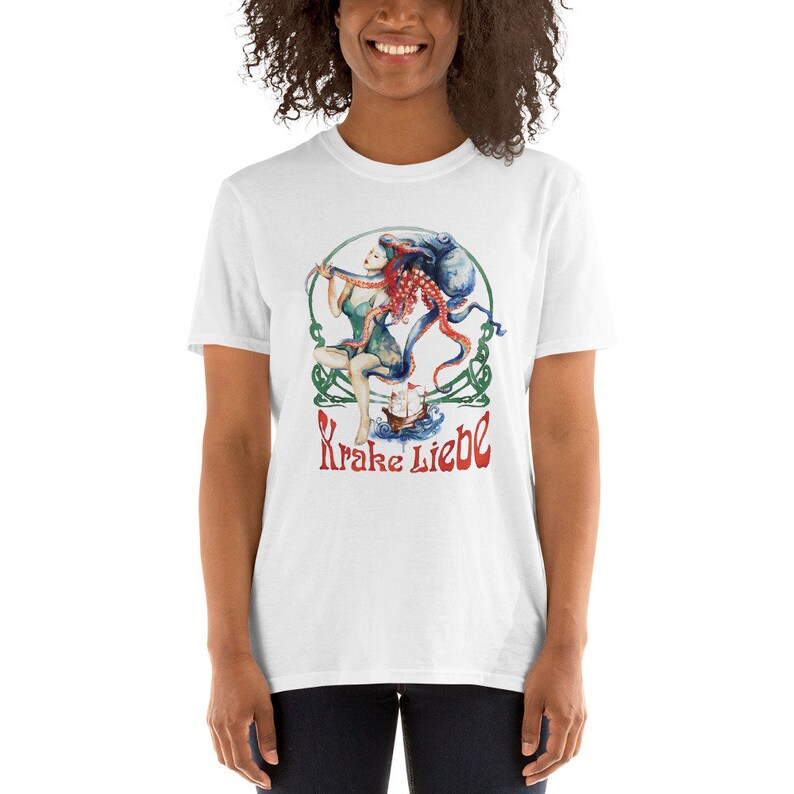 May include: White t-shirt featuring a colourful illustration of a woman with an octopus on her head. The text "Krake Liebe" is printed below the illustration.