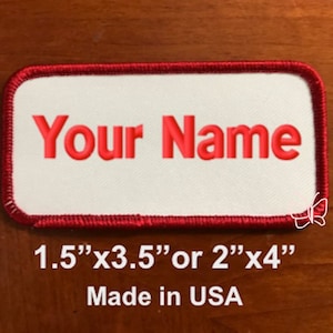 May include: White rectangular patch with a red border. The text "Your Name" is embroidered in red. The patch is available in two sizes: 1.5" x 3.5" or 2" x 4". Made in the USA.