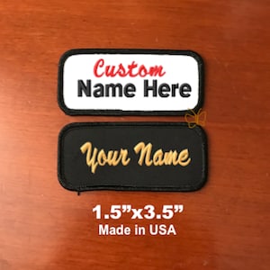 May include: Two embroidered patches, one white with red text "Custom Name Here" and one black with gold text "Your Name", both 1.5 inches by 3.5 inches. Made in the USA.
