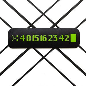 Puede incluir: Una pantalla digital negra y verde con el texto ">:4815162342" y un cuadrado verde al final.