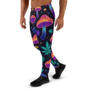 Könnte beinhalten: Schwarze Jogginghose mit einem lebendigen, psychedelischen Muster. Das Design zeigt bunte Pilze, Cannabisblätter und Sterne auf einem dunkelblauen Hintergrund. Die Jogginghose hat eine figurbetonte Passform mit bequemem Bund und Bündchen.