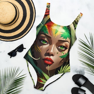 May include: A one-piece swimsuit with a colorful, abstract design featuring a woman's face surrounded by green leaves. The woman has green eyes and red lips.
