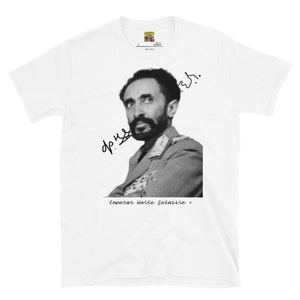 May include: White t-shirt with a black and white photo of Emperor Haile Selassie I. The photo shows him in a military uniform with his signature below the image. The text "Emperor Haile Selassie I" is printed below the signature.
