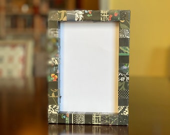Decorative black picture frame, striped, collaged with vintage and recycled papers