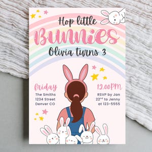 May include: A pastel-colored invitation with the text "Hop little Bunnies" and "Olivia turns 3". The design includes a rainbow, stars, and illustrations of bunnies. The invitation also includes event details.