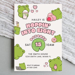 Puede incluir: Una invitación de color crema con un tema de rana. El texto dice "Hailey is Hoppin' Into Eight" con la fecha del 15 de octubre. La invitación incluye ilustraciones de ranas, corazones y otros gráficos.
