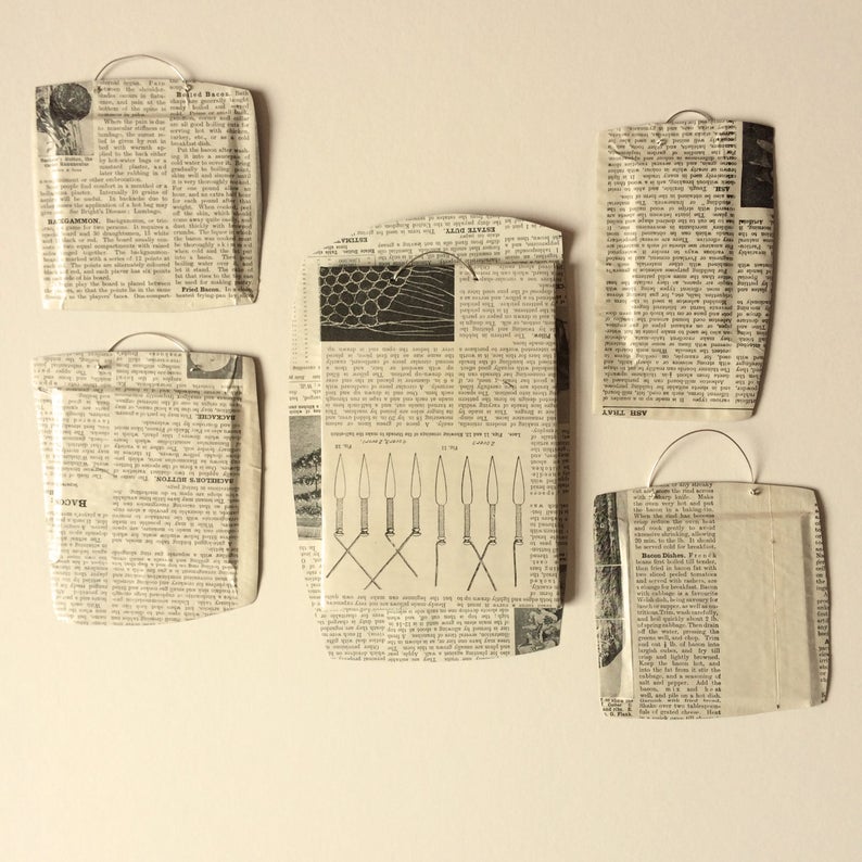 May include: Five framed pieces of newspaper clippings, each with a different article. The frames are made of metal and have a wire hanger on the back.
