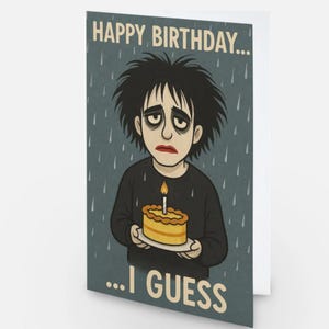 May include: A rectangular greeting card featuring a cartoon illustration of a person with messy black hair and dark eye makeup, holding a small yellow birthday cake with a single lit candle. The text reads HAPPY BIRTHDAY... ...I GUESS.
