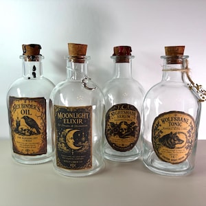 May include: Four clear glass bottles with cork stoppers, each featuring a unique vintage-style label. The labels read Hex Binder's Oil, Moonlight Elixir, Nightshade Serum, and Wolfsbane Tonic. Some bottles have decorative wax seals or charms.