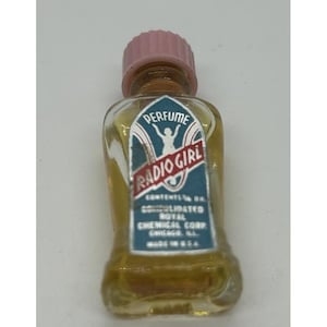 May include: Vintage perfume bottle with a pink cap. The label reads "PERFUME RADIO GIRL" with a graphic of a woman. The bottle is filled with a golden liquid. The label also includes the text "CONTENTS 1/8 OZ. CONSOLIDATED ROYAL CHEMICAL CORP. CHICAGO, ILL. MADE IN U.S.A."