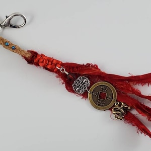 Pretty Chinese New Year is a stunning purse charm and or key chain with red sari silk and a dragon charm.