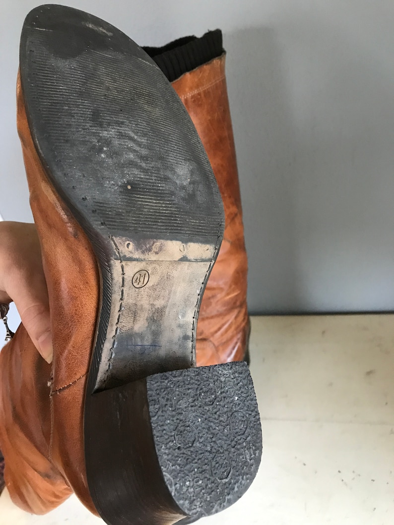 scuffed marked stained brown leather boots with