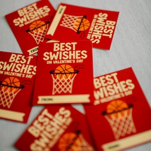 May include: Red Valentine's Day cards with basketball-themed graphics. Each card features a basketball going into a hoop and the words "Best Swishes on Valentine's Day". Some cards have "From" printed on them.