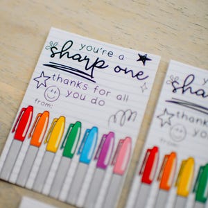 Könnte beinhalten: Eine druckbare Lehrer-Dankeskarte mit dem Text "You're a sharp one. Thanks for all you do." Die Karte zeigt eine Reihe bunter Marker und ein Smiley.