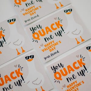 May include: Five Valentine's Day cards featuring a cartoon goose wearing sunglasses. The cards are beige with orange and black text that reads "You quack me up! Happy Valentine's Day. Your friend."