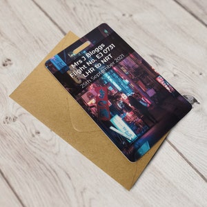 May include: A boarding pass with a photo of a city street at night. The text on the pass reads "Mrs. J Bloggs Flight No. EJ 0731 LHR to NRT 25th September 2021".