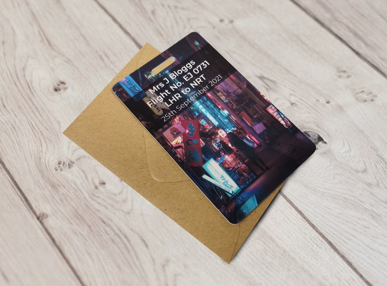 May include: A boarding pass with a photo of a city street at night. The text on the pass reads "Mrs. J Bloggs Flight No. EJ 0731 LHR to NRT 25th September 2021".