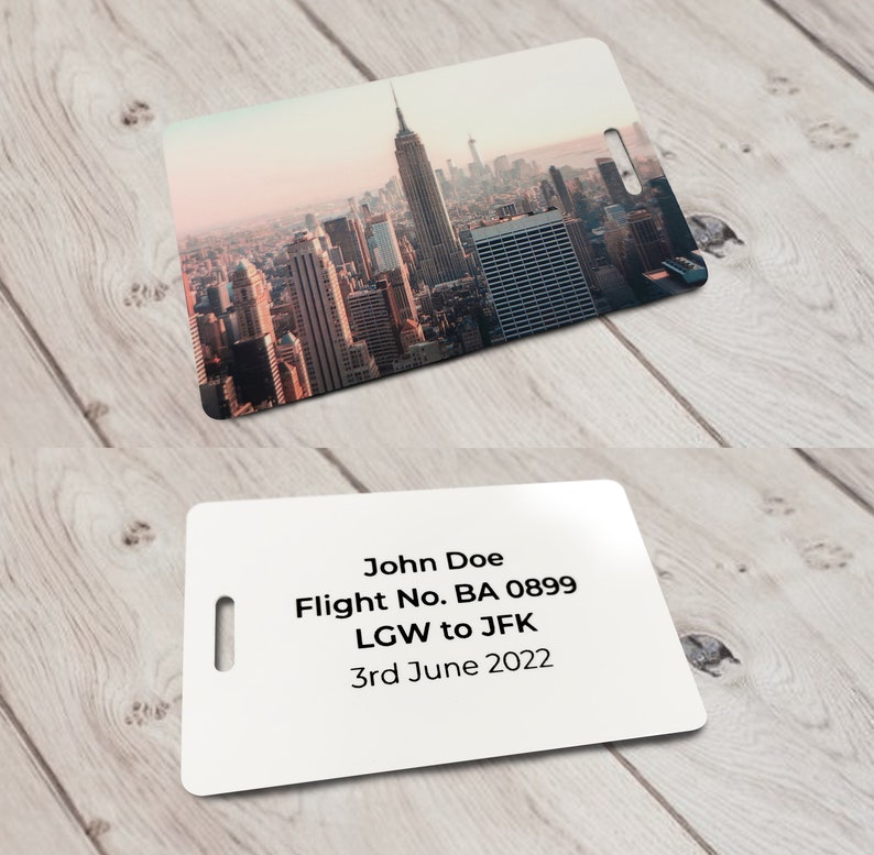 May include: White luggage tag with black text. The text reads "John Doe, Flight No. BA 0899, LGW to JFK, 3rd June 2022".