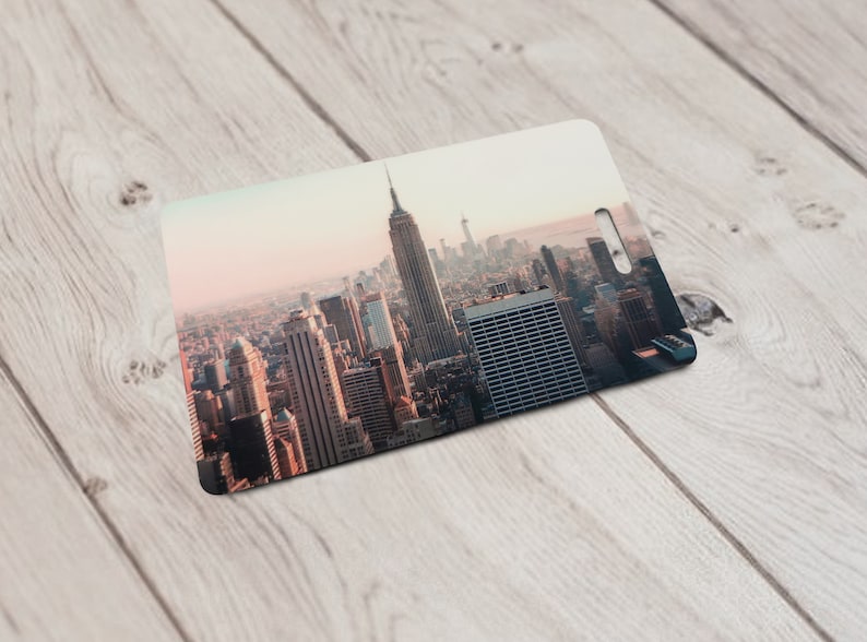May include: A close-up view of a cityscape with tall buildings, including the Empire State Building, in the background. The city is bathed in a warm, golden light, creating a sense of vibrancy and energy.