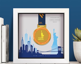 Może przedstawiać: Biała ramka typu shadow box zawierająca złoty medal zawieszony na ciemnoniebieskiej wstążce. Tło przedstawia niebieską sylwetkę panoramy Nowego Jorku, Statuę Wolności oraz tekst 3rd November 2024, CHARLIE CADENCE, 03:04:41.