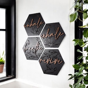 May include: Black hexagonal wall decor with floral designs and the words "inhale", "exhale", "breathe", and "revive" in copper lettering.
