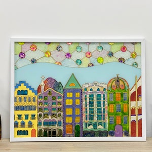 Könnte beinhalten: Ein farbenfrohes, gerahmtes Kunstwerk, das eine Reihe skurriler Gebäude darstellt. Die Gebäude sind in leuchtenden Farben von Gelb, Lila, Grün und Blau mit komplizierten Details bemalt. Der Himmel ist hellblau mit bunten kreisförmigen Mustern.