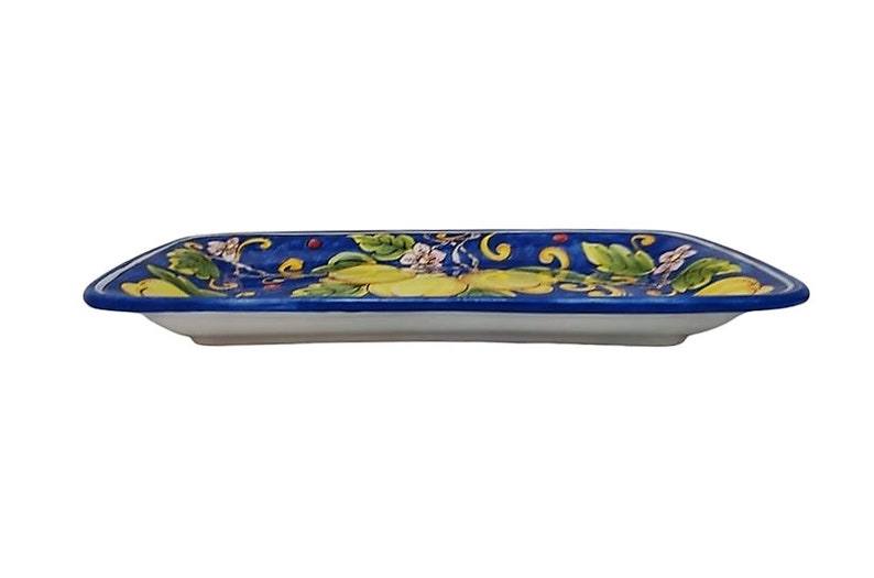 May include: A rectangular ceramic serving dish with a white base and a vibrant blue rim. The dish is decorated with a floral pattern featuring yellow, green, and white flowers and leaves. The design is symmetrical, with the floral elements arranged along the edges.