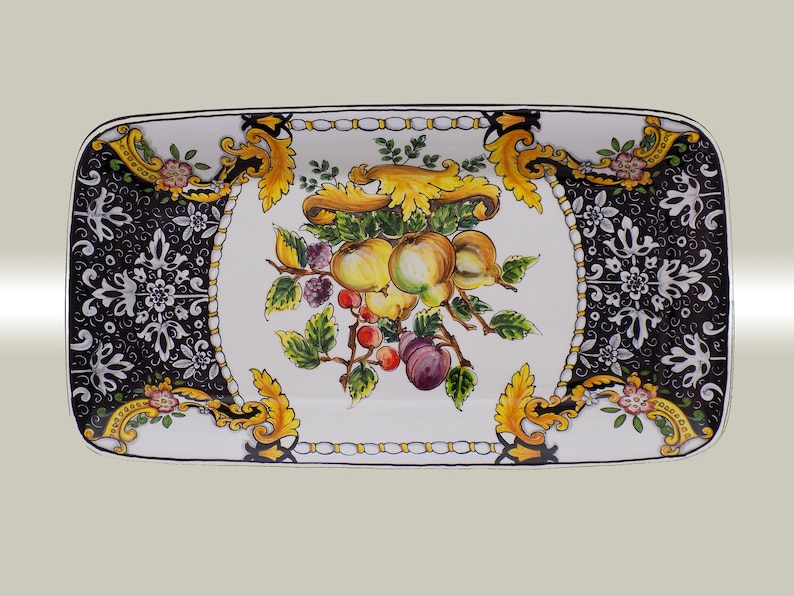 Puede incluir: Bandeja rectangular de cer&aacute;mica con dise&ntilde;o de frutas pintado a mano. El centro presenta una naturaleza muerta de manzanas, ciruelas y bayas. El borde tiene un patr&oacute;n floral en blanco y negro con detalles dorados.