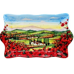 May include: Rectangular ceramic serving platter with a hand-painted Italian landscape scene. The design features rolling green hills, white buildings, and vibrant red poppies. The rim is scalloped and decorated with more poppies.